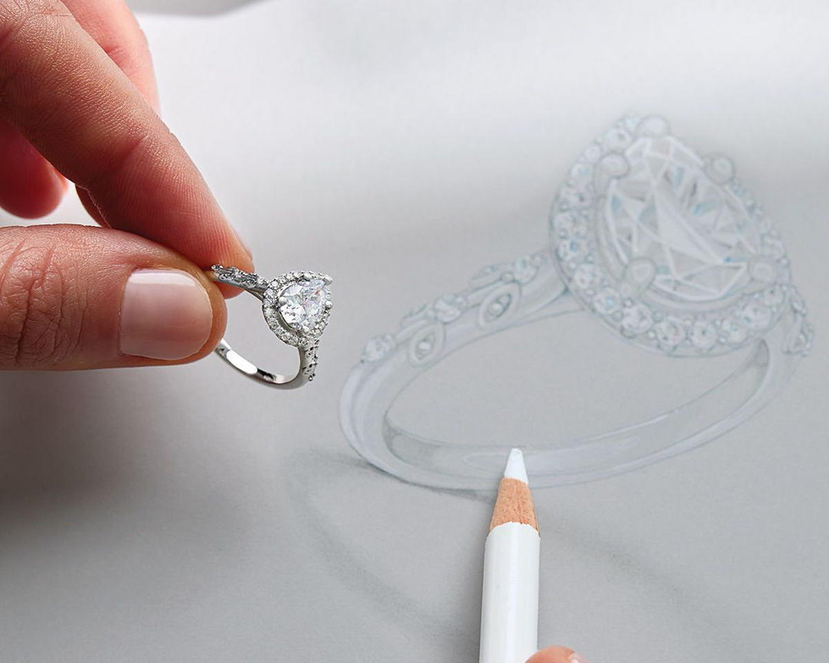 Final piece on linen surface beside the original hand-rendered sketch