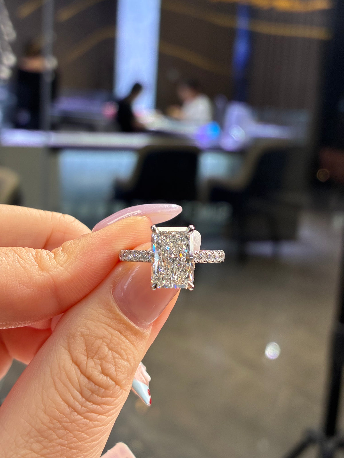 For Aleli, 3.05ct radiant cut diamond, D/VVS2, with 0.473ct sidestones, total 3.5ct, in 14k white gold